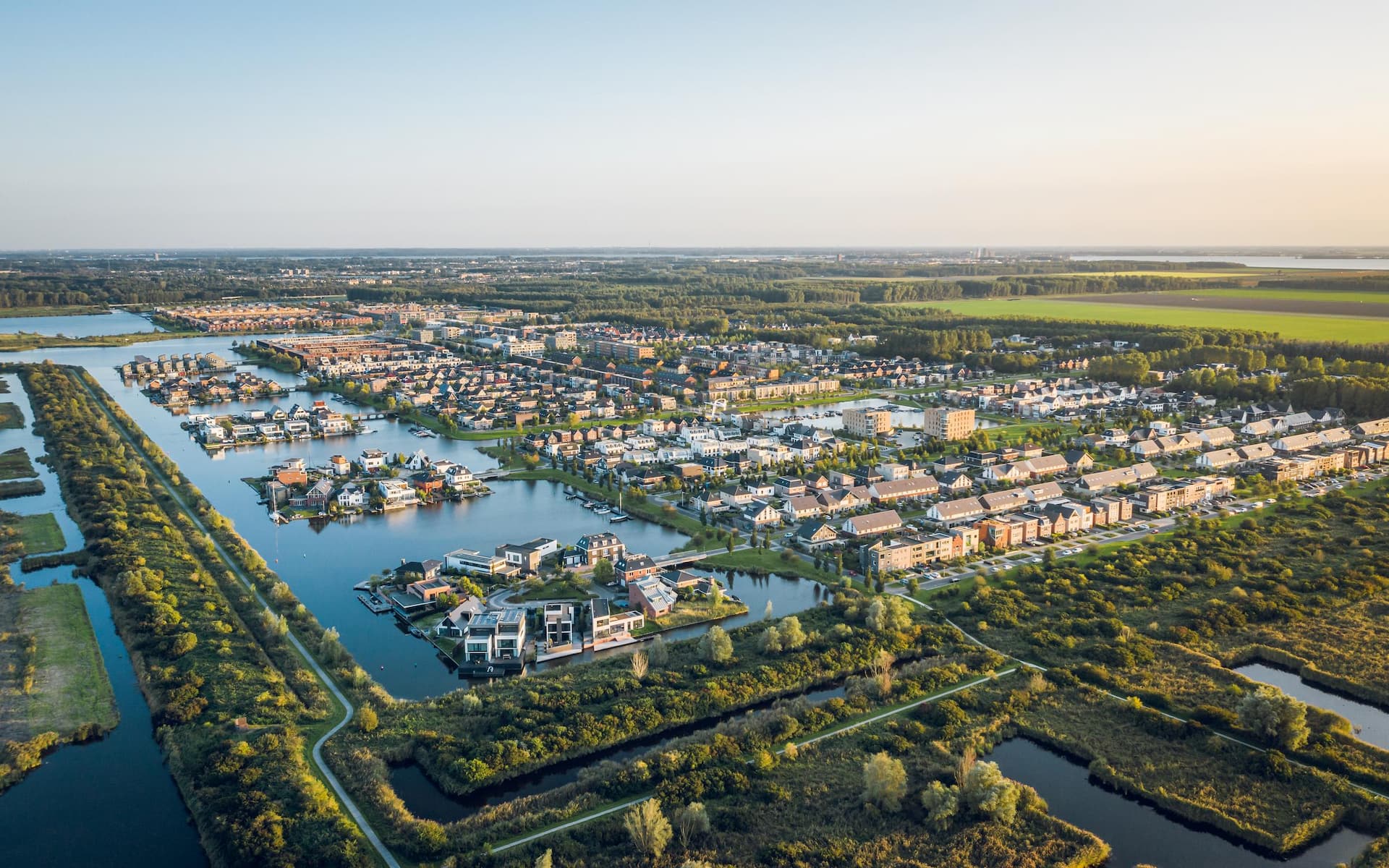 Modern suburban area Noorderplassen in Almere, The Netherlands, featuring artificial islands, located on Flevoland polder, surrounded by nature and the Nieuwe Land national park. Aerial view.
