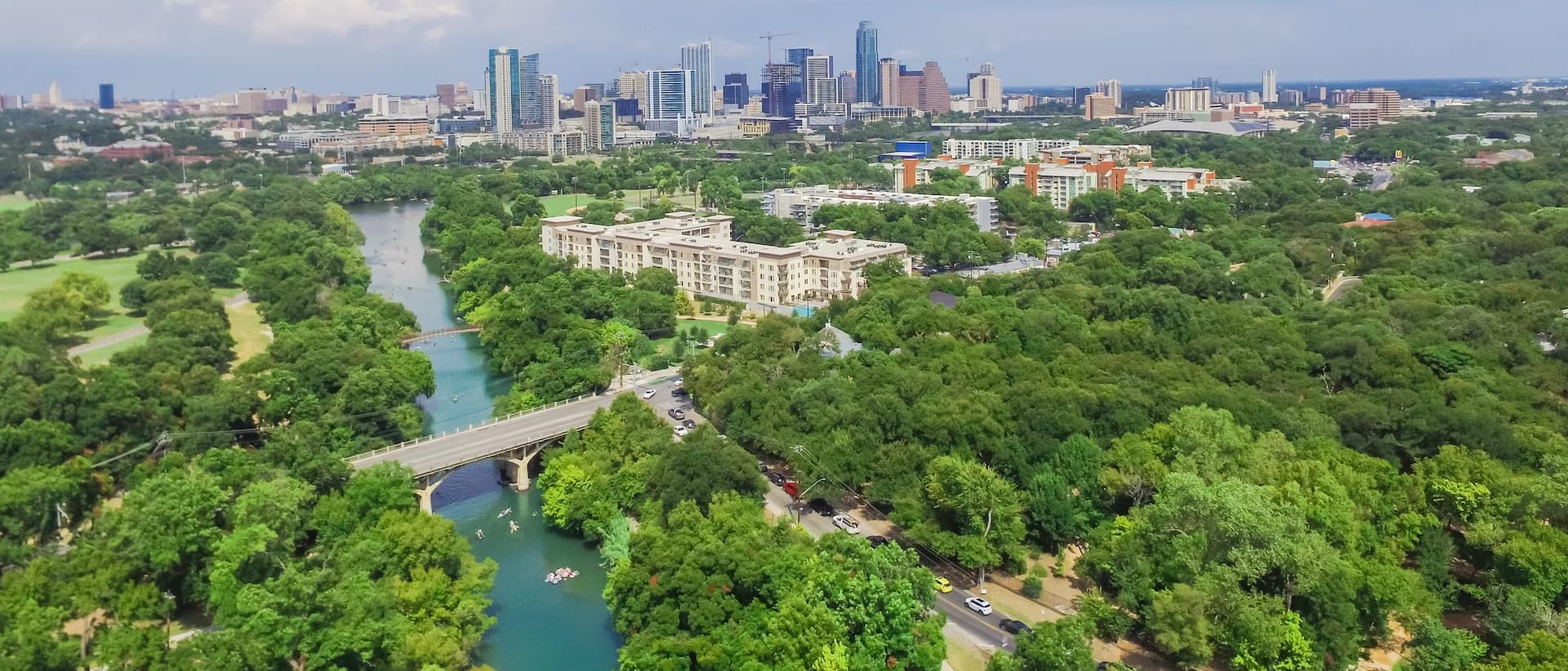 Panorama aerial view Downtown from Barton Creek in Greenbelt at Zilker Metropolitan Park south Austin with summer blue cloud sky. Located at eastern edge of Hill Country, is the state capital of Texas