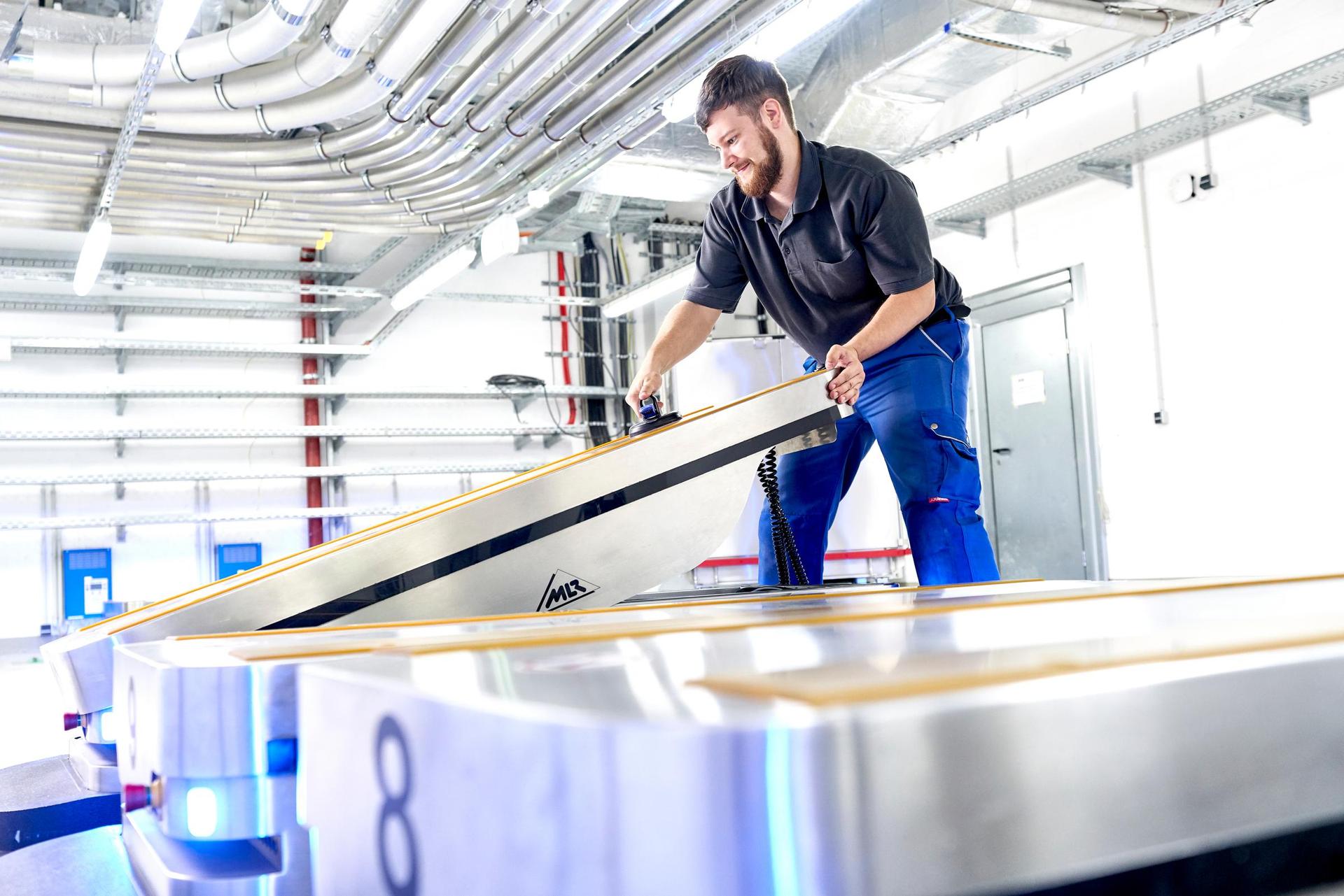 Employee doing maintenance work for automated guided vehicles (AGV) at Bremen hospital (Klinikum Bremen-Mitte)