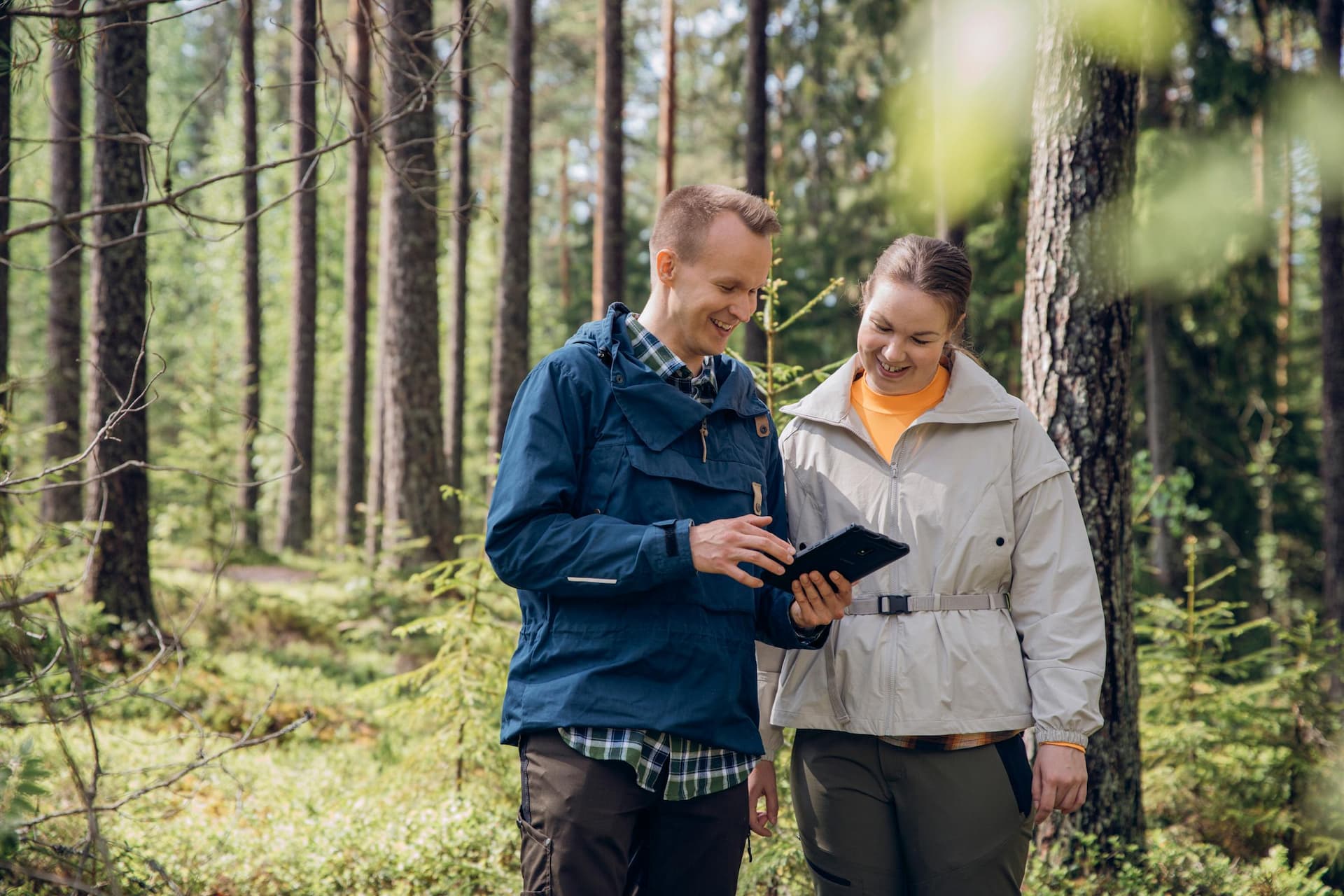 RFI brand photoshoot in Espoo, Finland. Two Environmental Specialist checking an iPad in a forest, Nuuksio National Park, Finland.